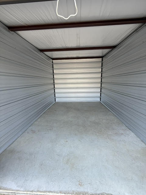 Inside a wide, empty storage unit with a concrete floor