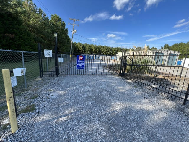 Black iron entrance gate with a keypad at Mimi’s Mini Storage