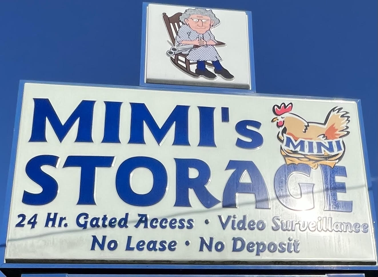 Mimi’s Mini Storage sign advertising 24-hour gated access, video surveillance, no lease and no deposit