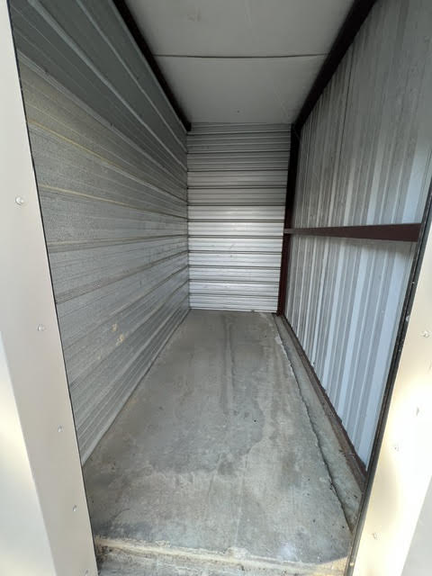 Inside an empty storage unit with steel walls and a concrete floor