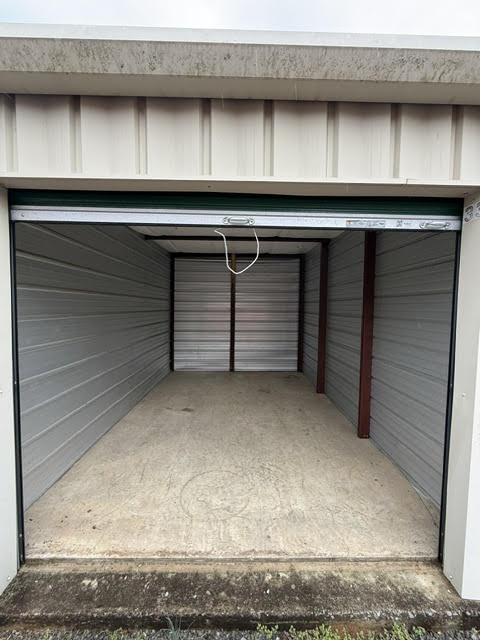 Inside an empty storage unit with the roll-up door open